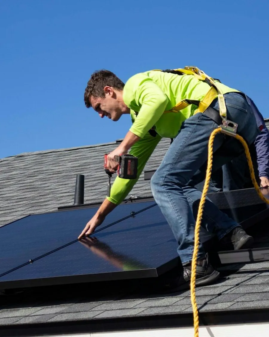 A Prime Volt installer working on a residential rooftop array